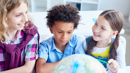 children with teaher and globe.jpg